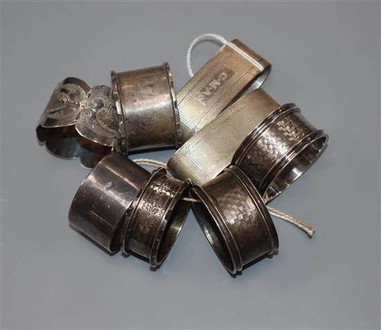 Eight assorted silver napkin rings including one pair and one enamelled with a butterfly.